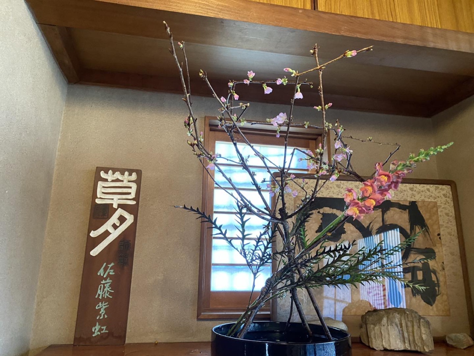 自宅教室の床の間に置かれた春の枝と桃色の花のいけばな