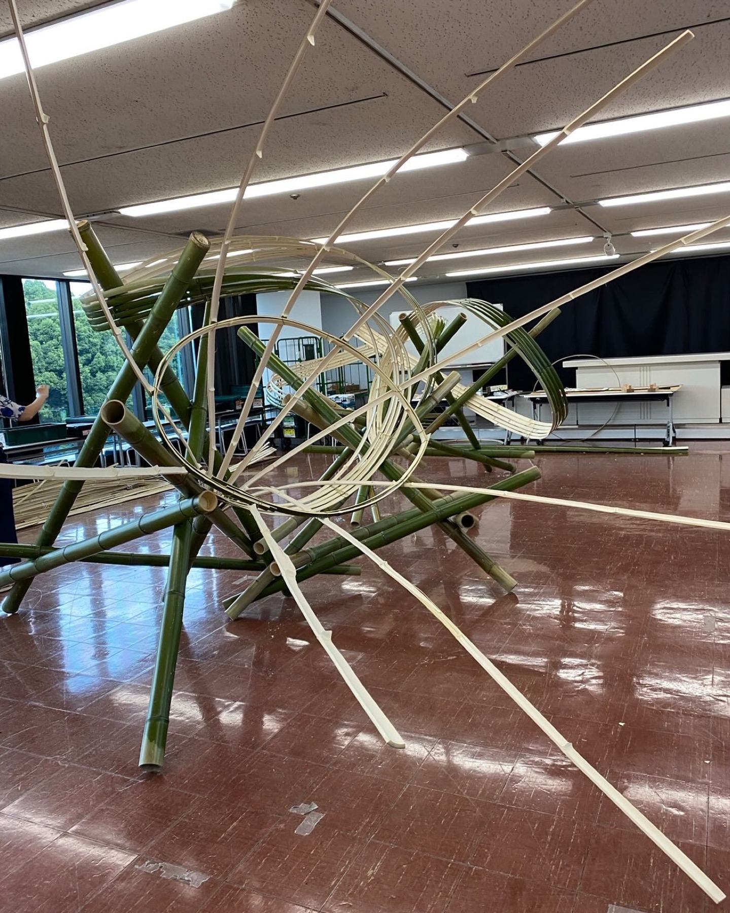 竹を大胆に組み、白い曲線が空間を走る大型いけばな作品