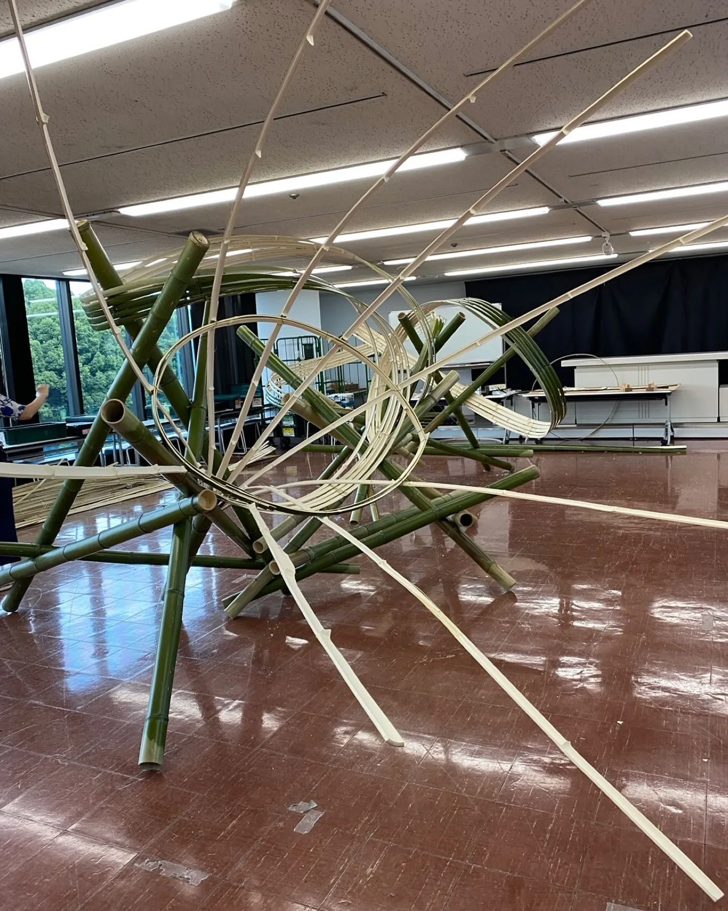 竹を大胆に組み、白い曲線が空間を走る大型いけばな作品