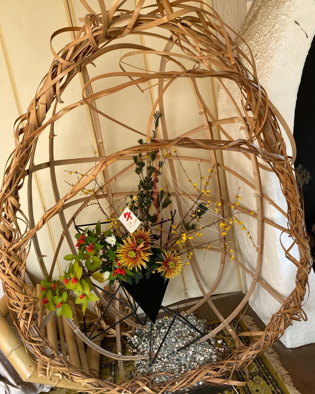 竹の輪と黄色い花を組み合わせた正月のいけばな作品